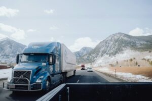 A Semi-Truck driving safety on a winter road after having maintenance performed.