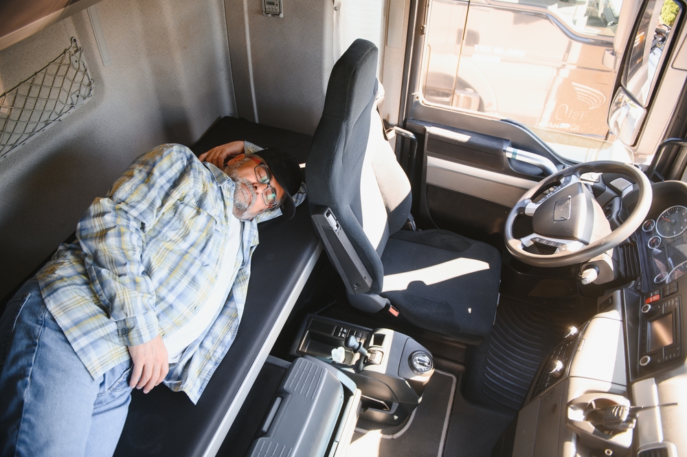 A trucker prioritizing adequate rest in his truck cabin.