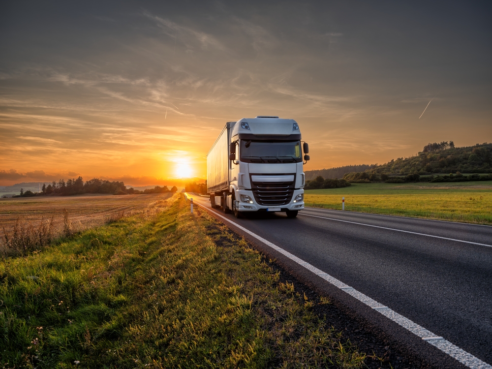 An OTR Trucker driving away from the sunset.